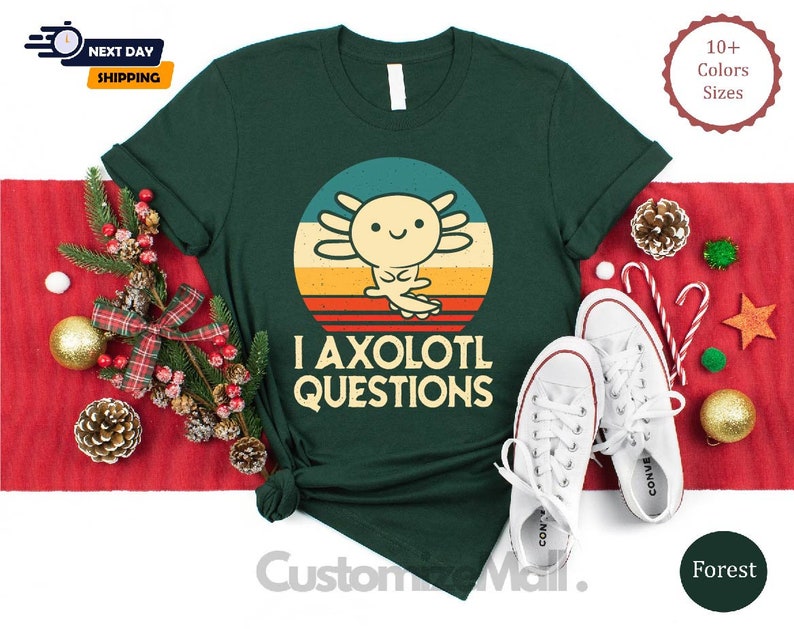 May include: A green t-shirt with a retro-style sunset graphic featuring an axolotl. The text "I axolotl questions" is printed below the graphic.