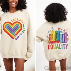 May include: A beige sweatshirt with a rainbow heart and the text "Equality Hurts No One" on the front. The back of the sweatshirt has a rainbow stack of books with the text "Love Equality" on the bottom.