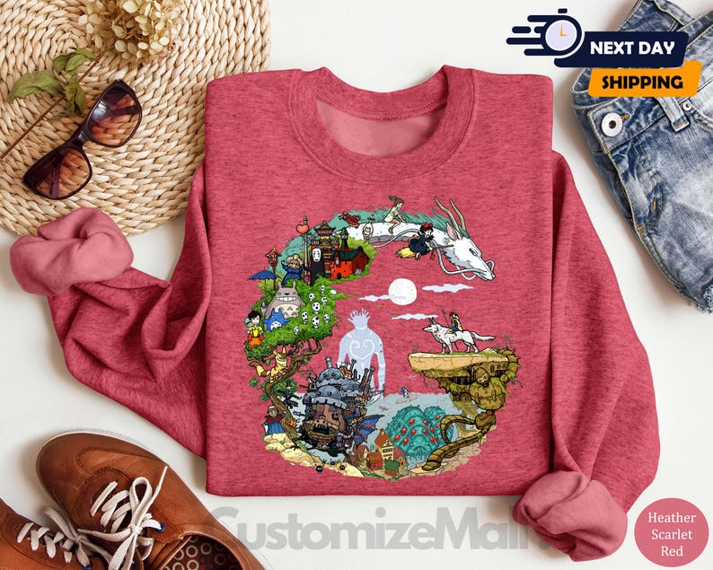 a red sweatshirt with a colorful illustration of a dragon, a castle, and various other elements, along with a pair of jeans and a pair of sunglasses.
