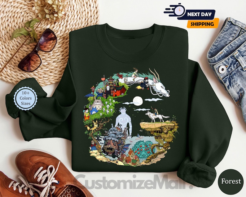 a green sweatshirt with a colorful illustration of a dragon, a castle, and various other fantastical elements, along with a pair of sunglasses and a pair of jeans.