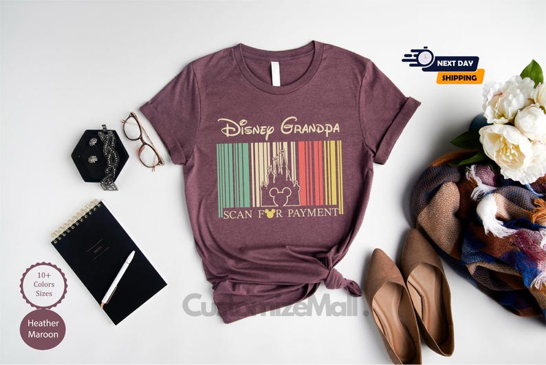 a purple t-shirt with a Disney Grandpa design, along with various accessories such as a notebook, a pen, a pair of glasses, and a bouquet of flowers.
