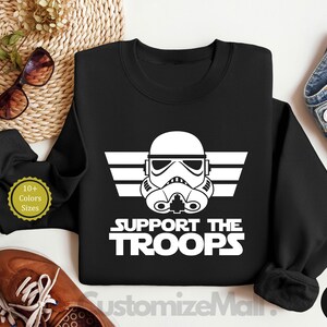 May include: Black sweatshirt with a white graphic of a Star Wars Stormtrooper helmet with the text "Support the Troops".