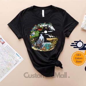 a black t-shirt with a colorful, circular design on it, placed on a table alongside a map and some text.