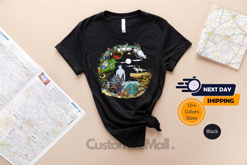 a black t-shirt with a colorful, circular design on it, placed on a table alongside a map and some text.