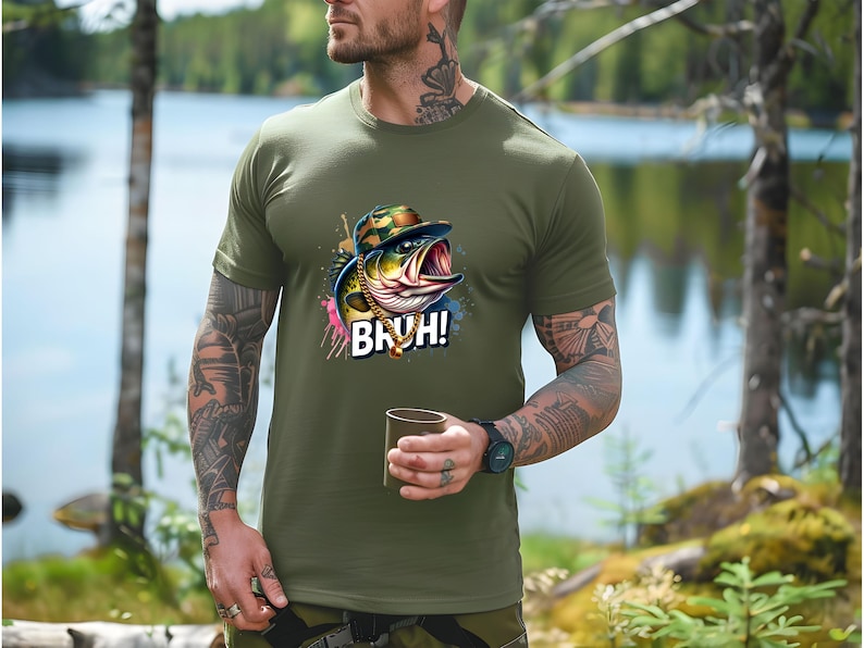 May include: Olive green t-shirt featuring a cartoon bass wearing a camouflage hat and gold chain, with the word "BRUH!" in white. The shirt is made of a soft material.