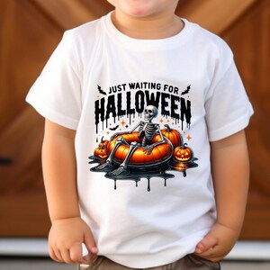 May include: White t-shirt with a skeleton wearing a pumpkin float and the text "Just Waiting for Halloween".