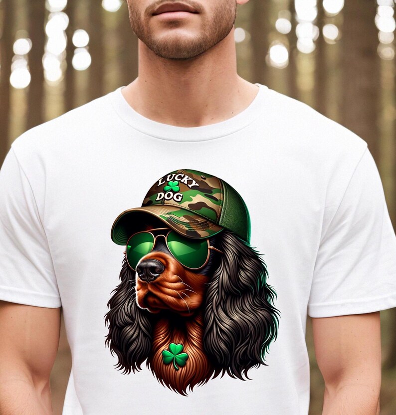 May include: White t-shirt with a cartoon image of a brown and black dog wearing a camouflage baseball cap with the text "Lucky Dog" and green shamrocks. The dog is wearing green sunglasses and has a green shamrock around its neck.