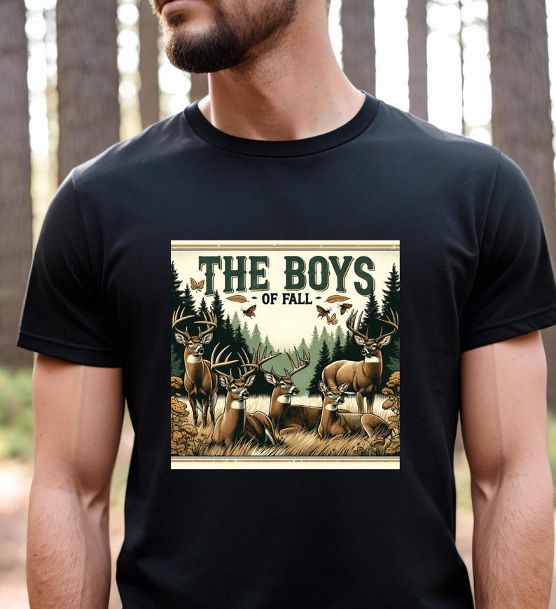 K&ouml;nnte beinhalten: Ein schwarzes T-Shirt mit einer Grafik im Vintage-Stil von einer Gruppe Hirsche in einem Wald. Die Grafik lautet "The Boys of Fall".
