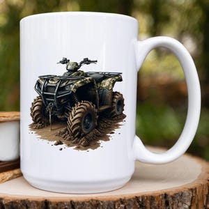 May include: White ceramic mug with a graphic of a camouflage ATV driving through mud. The ATV has black wheels and a black roll cage.
