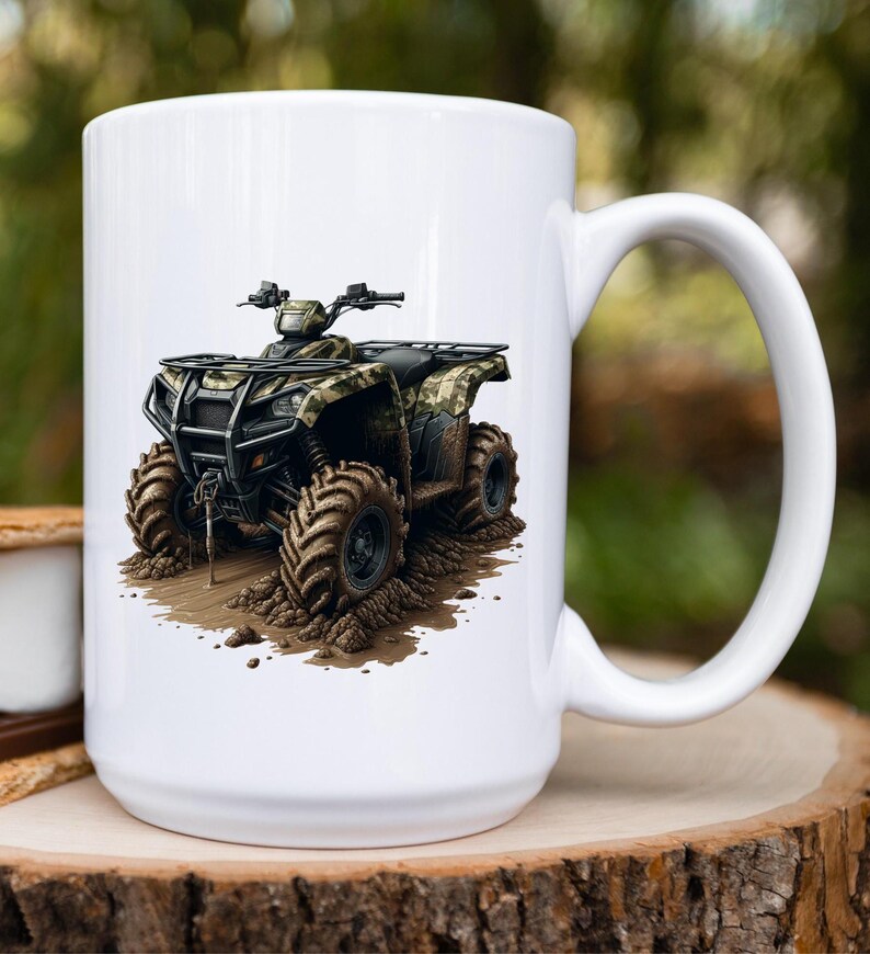 May include: White ceramic mug with a graphic of a camouflage ATV driving through mud. The ATV has black wheels and a black roll cage.
