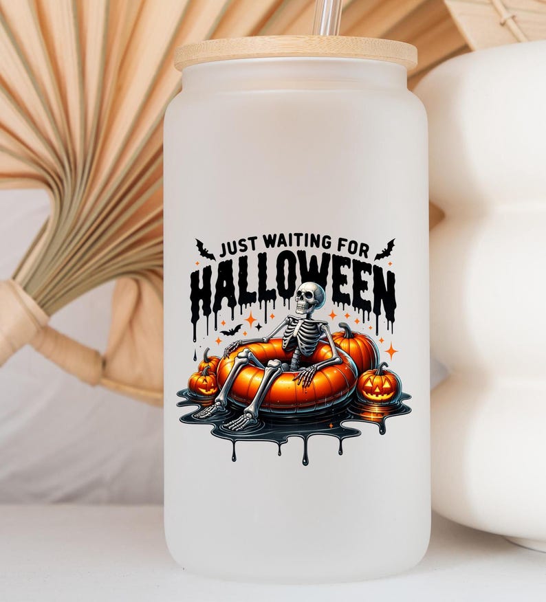 May include: White frosted glass water bottle with a bamboo lid and a black and orange graphic of a skeleton in a pumpkin-shaped inner tube. The graphic says "Just Waiting for Halloween".