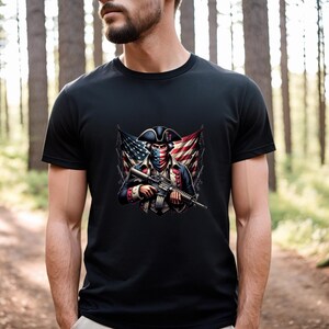 May include: A black t-shirt with a graphic of a man dressed as a revolutionary soldier holding a rifle. The soldier is wearing a bandana over his face, and the American flag is behind him.
