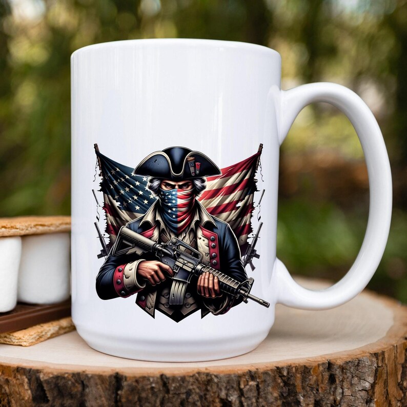 May include: White ceramic coffee mug with a graphic of a person wearing a tri-corner hat and a bandana with the American flag colors, holding a rifle. The person is standing in front of a tattered American flag.