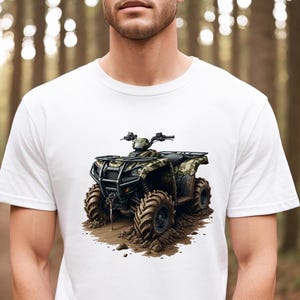 May include: White t-shirt with a graphic of a camouflage ATV driving through mud.
