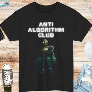Peut inclure: T-shirt noir avec un robot blanc et le texte "ANTI ALGORITHM CLUB".