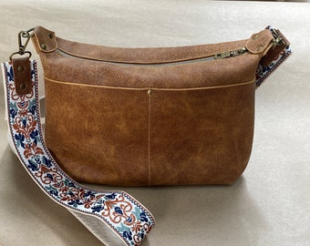 Women’s leather shoulder/crossbody purse. Multiple pockets inside and out, fully lined with  cotton fabric. 48 in strap.