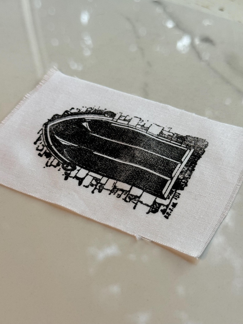 May include: A black and white printed fabric patch featuring a detailed illustration of an arched doorway with a brick pattern.
