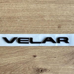 May include: Black plastic "VELAR" lettering on a white background.