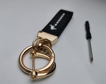 Portachiavi Bronco Sport ST RS | Logo in carbonio e pelle | Emblema in lega di zinco | Accessorio per auto 125 mm x 34 mm