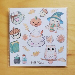 May include: A square sticker sheet featuring fall-themed illustrations. Designs include a pumpkin, acorns, owls, a witch owl, coffee, and leaves. The phrase "Fall Vibes" is written at the bottom. The color palette includes orange, brown, green, and white.