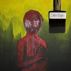 May include: A dark perfume bottle with a silver cap and a label that reads "Mon Enfer" is set against a painting of a red figure with a yellow and green background. The artwork has a dark, moody aesthetic.