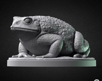 May include: A grey 3D printed model of a toad, sitting on a round base. The toad has a textured, bumpy surface and is posed with its legs tucked underneath its body.
