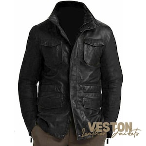 Könnte beinhalten: Schwarze Lederjacke mit Stehkragen und mehreren Vordertaschen. Die Jacke hat einen Reißverschluss und eine taillierte Passform. Die Ärmel sind lang und das Leder wirkt abgenutzt. Die Jacke ist ein klassischer Stil.