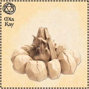 May include: A beige miniature volcano model surrounded by beige rocks. The model has a textured surface and is designed for tabletop gaming. The Mia Kay logo is in the upper left corner.