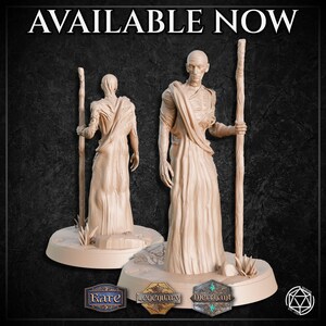 May include: Two beige-colored statues of robed figures holding staffs, set on circular bases. The statues are detailed with draped clothing and realistic facial features. The text "AVAILABLE NOW" is at the top of the image, with three badges at the bottom.
