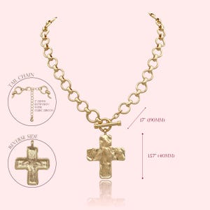 May include: Gold-tone cross pendant necklace. The necklace features a textured cross pendant and a chain with a toggle clasp. The chain is 17 inches (90mm) long, and the cross pendant is 1.57 inches (40mm) in length. The necklace has a tail chain with a 2-inch extension.