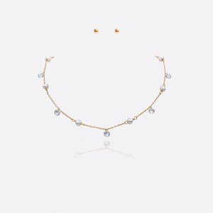 May include: A gold necklace with a delicate chain and small pearl and crystal accents. The necklace is paired with matching gold stud earrings.