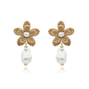 May include: A pair of gold tone earrings with a woven flower design and a white pearl drop.