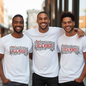 May include: Three people wearing white t-shirts with a black and red word cloud design that says "Social Worker". The word cloud is shaped like a heart. The people are standing in front of a brick building.