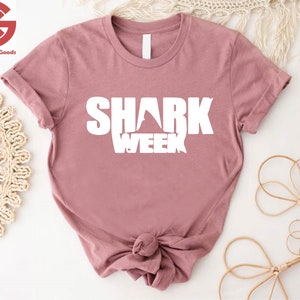 a pink shirt with the words shark week on it