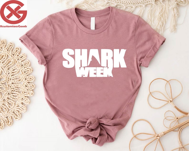 a pink shirt with the words shark week on it