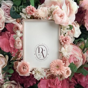 Op de afbeelding: Een rechthoekige, lichtgekleurde fotolijst met de tekst "DIGITAL ARTISTRI CREATIONS" in een cirkel, omringd door een verscheidenheid aan roze en rode bloemen, waaronder rozen en pioenrozen. De bloemen vormen een rand rond de lijst.