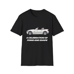 May include: A black t-shirt with a white illustration of a convertible car and the text "A celebration of form and shape".