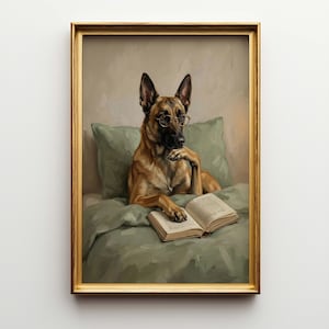 May include: A framed print depicts a dog wearing glasses, resting in bed with a book. The dog is a light brown color with black ears and a black nose. The bed linens and pillow are a muted green. The frame is gold.