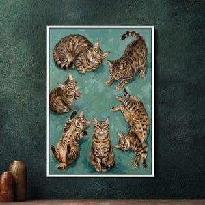 Może przedstawiać: Oprawione dzieło sztuki przedstawiające siedem brązowych i płowych kotów pręgowanych w różnych zabawnych pozach na turkusowym tle. Koty mają szczegółowe wzory sierści i ekspresyjne twarze, tworząc kapryśną scenę. Grafika jest prezentowana w białej ramie.