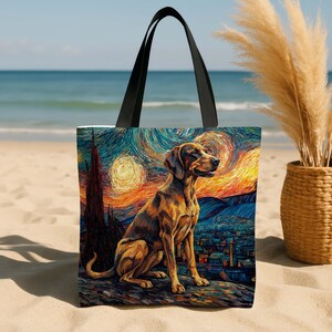 May include: Tote bag featuring a painting of a dog in the style of Van Gogh's "Starry Night." The dog is brown and tan, sitting on a rock with a city and swirling sky in the background. The bag has black handles.