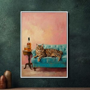 Può includere: Dipinto incorniciato di un gatto tabby sdraiato su un divano turchese. Un tavolino accanto contiene una bottiglia di liquore ambrato e un bicchiere. Lo sfondo è rosa tenue, creando un'estetica vintage.