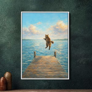 Può includere: Una stampa artistica incorniciata raffigura un gatto tigrato che salta sopra un molo di legno. Il gatto, marrone e beige, si staglia su uno sfondo di lago blu e cielo con nuvole soffici. Il molo è in legno stagionato, aggiungendo un tocco rustico alla scena.