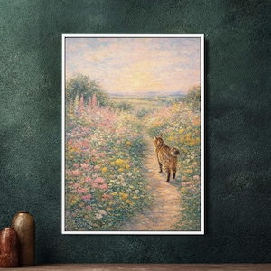 Op de afbeelding: Een ingelijst schilderij toont een tijgerkat die over een pad loopt door een veld met kleurrijke wilde bloemen. Het kunstwerk heeft een zachte, impressionistische stijl met een warm kleurenpalet van roze, geel en groen, met een zonsondergang op de achtergrond.