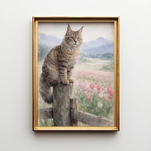 May include: A framed painting of a cat sitting on a wooden fence post, overlooking a field of pink flowers and distant mountains. The cat has brown and tan fur, with green eyes. The frame is gold.