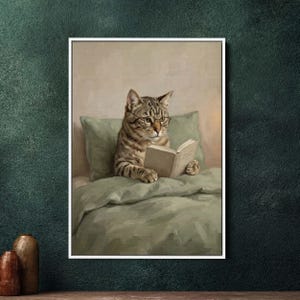 Może przedstawiać: Oprawiony wydruk przedstawia kota pręgowanego w okularach czytającego książkę w łóżku. Kot jest otoczony zieloną pościelą i poduszką. Grafika ma styl vintage i malarski, z miękkimi kolorami i przytulną atmosferą.
