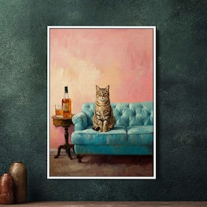 Może przedstawiać: Oprawiony obraz przedstawia kota pręgowanego siedzącego na turkusowej, pikowanej sofie. Mały okrągły stolik trzyma butelkę bursztynowego likieru i szklankę. Tło jest w kolorze jasnoróżowym, a obraz jest w białej ramie.