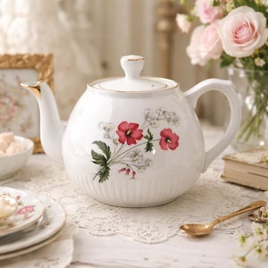 Puede incluir: Una taza de cerámica blanca con un asa negra y el texto "But First, Coffee" en negro, en negrita. La taza está sobre una superficie blanca.