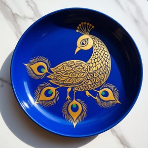 Peut inclure: Une assiette ronde en céramique bleu profond ornée d'une illustration stylisée de paon doré au centre. Le motif du paon présente des lignes complexes sur le corps et quatre plumes de queue proéminentes, chacune accentuée d'un petit détail vert.