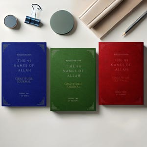 Pode incluir: Três diários de capa dura com letras douradas sobre uma superfície branca. Os diários são azul, verde e vermelho. O texto nas capas diz "Reflexão sobre os 99 nomes de Alá Diário de gratidão". Os diários são etiquetados como "Diário um", "Diário dois" e "Diário três".