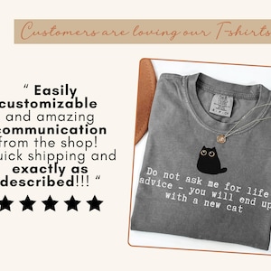 May include: A charcoal gray t-shirt featuring a black cat illustration and the white text: Do not ask me for life advice - you will end up with a new cat. The image includes a five-star review and the text: Customers are loving our T-shirts.